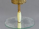 a glass table with a gold plate on top of it