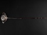 a silver spoon with a flower on it on a black surface