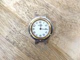 une montre en argent et en or posée sur une table en bois