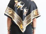 the back of a woman in a black dress with a black and gold shawl