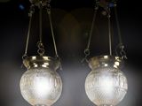 pair of antique glass hanging lamps in a dark room