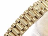 an image of a gold watch bracelet with a diamond on the clasp