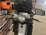 a motorcycle that is parked in a garage next to a pile of wood