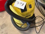 un sèche-cheveux jaune et noir posé par terre