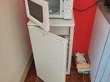 a small white microwave sitting on top of a small white refrigerator