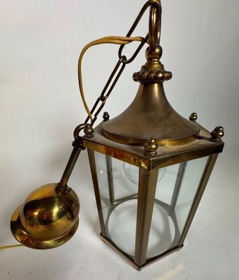 une lanterne ancienne en laiton avec une cloche et une cuillère en laiton