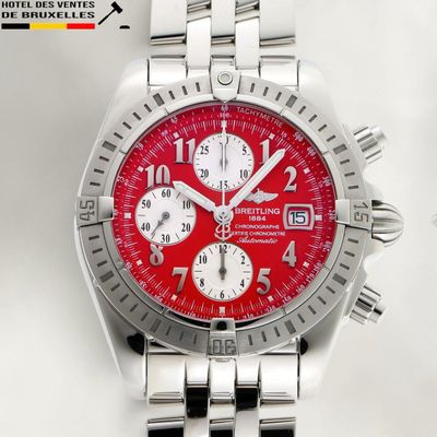 a close up of a wrist watch with a red dial