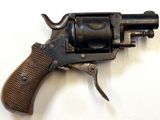 un vieux pistolet avec une poignée en bois sur une surface blanche