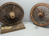 deux vieilles roues en bois exposées dans une pièce