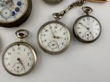 many different types of pocket watches on the table