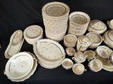 a lot of white dishes and bowls on a black table