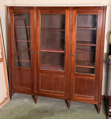 un grand meuble en bois avec des portes en verre dans une pièce