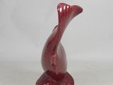 a red vase sitting on top of a white table