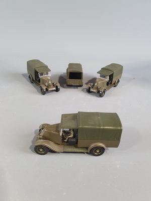 four toy trucks that are sitting on a white surface