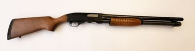 un vieux fusil posé sur une surface blanche, muni d'une crosse en bois