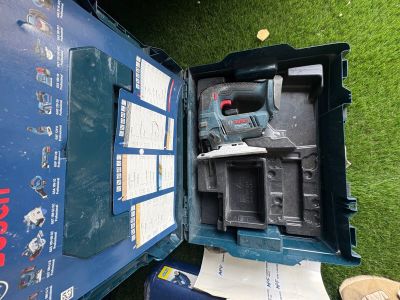 une boîte bleue contenant un outil, posée sur l'herbe