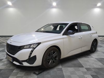 la voiture blanche est garée sur un sol en damier dans le garage