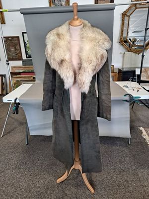une photo d'un manteau sur un mannequin dans une pièce