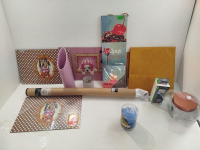 une table sur laquelle se trouvent un rouleau de papier, un rouleau de ruban adhésif, un rouleau de colle et d'autres objets