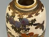 a vase with a floral design on it sitting on a table