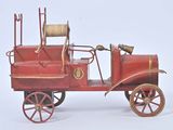 a red toy fire truck with a hose attached to the back of it