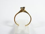 a close up of a gold ring with a black diamond on it