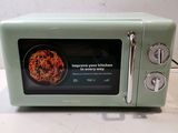 a small green microwave oven sitting on a counter