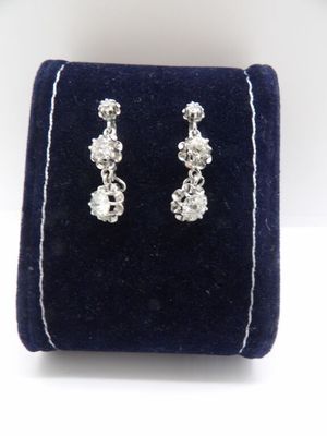 un gros plan sur une paire de boucles d'oreilles posées sur un étui en velours