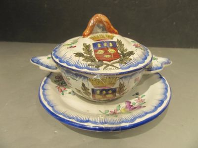 a bowl and saucer on a plate with a coat of arms on it
