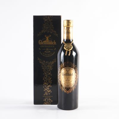 une bouteille de vin rouge à côté d'une boîte posée sur une surface blanche