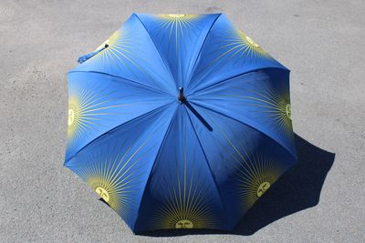 un parapluie bleu et jaune posé par terre