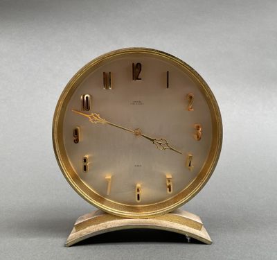 une horloge posée sur un support sur une table