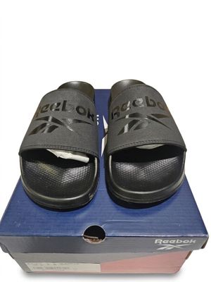 une boîte sur laquelle est posée une paire de sandales noires