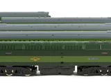 several green and black train cars sitting next to each other on a white surface