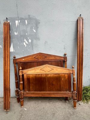 a bed with a wooden headboard and foot board next to a wall