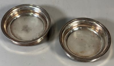 paire de bols plaqués argent posés sur un support blanc
