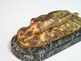 a bronze statue of a dog laying on a marble base
