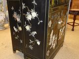 a black cabinet with flowers on it in a living room