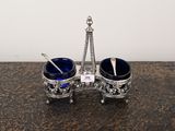 un ensemble de tasse et cuillère argentées et bleues posé sur une table