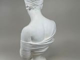 white marble bust of a woman with a turban on her head