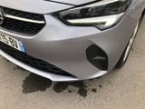 the front end of a silver car parked on the side of the road