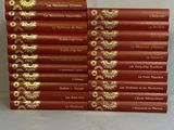 une pile de livres rouges ornés d'inscriptions dorées, posée sur une table