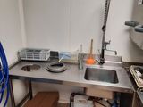a kitchen with a sink, stove, and other items in it