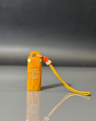 a small wooden book with a yellow cord on it