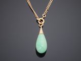 a gold necklace with a green tear shaped stone on a chain