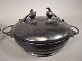 two birds sitting on top of a metal pot