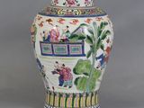 a vase with a painting on it sitting on a table