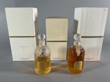 three bottles of perfume sitting next to each other on a table
