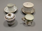 three cups and a saucer are sitting on a table