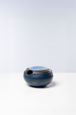 un bol bleu et noir posé sur une table blanche